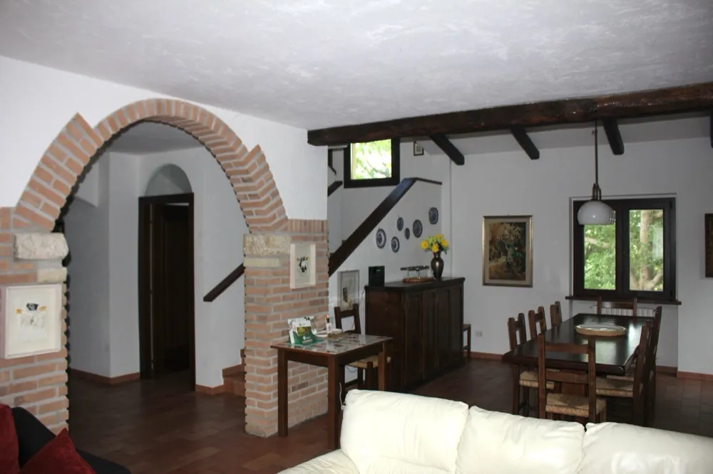 Salotto con arco in mattoni e travi a vista — Villa Le Venezie